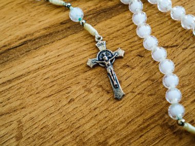 Hıristiyan güzel beyaz tespih İsa 'nın ahşap arka planda durduğu