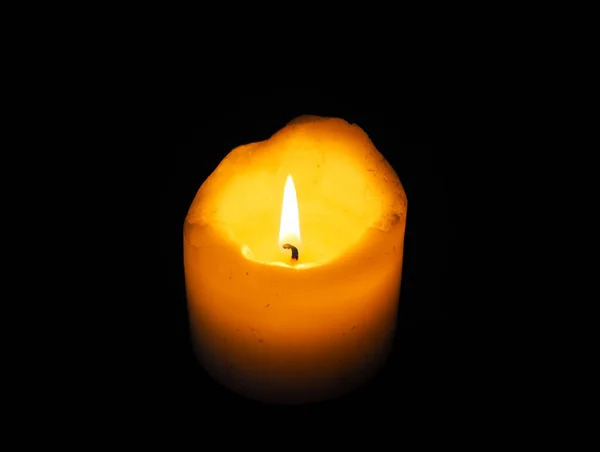 yanan mum, siyah arkaplanda mum. Mum geceleri yanıyor. Karanlık arka planda parlayan mum alevi. Yakın plan. Boş alan. Azizler Günü, Kasım 'da katolik kutlaması.