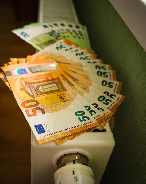 Cost of living crisis. Money on a home radiator heater. Rising cost of energy and bills