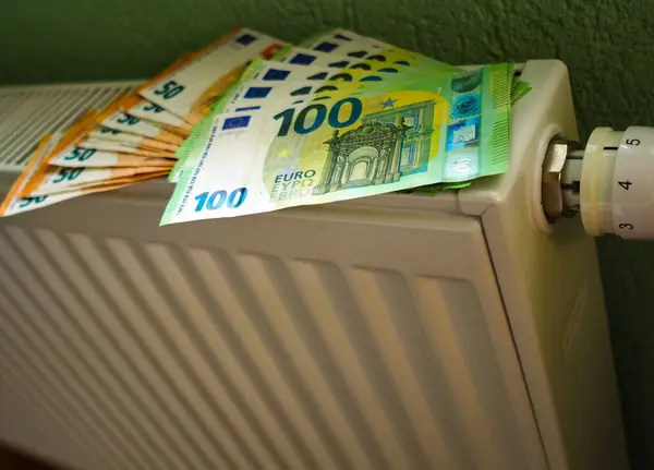 Cost of living crisis. Money on a home radiator heater. Rising cost of energy and bills