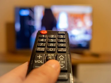 TV denetleyicisi TV 'deki düğmeye işaret ediyor