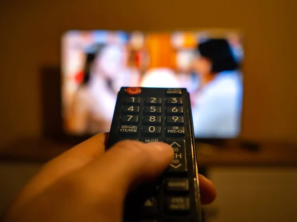 TV denetleyicisi TV 'deki düğmeye işaret ediyor