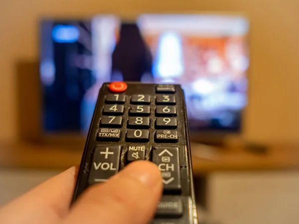 TV denetleyicisi TV 'deki düğmeye işaret ediyor