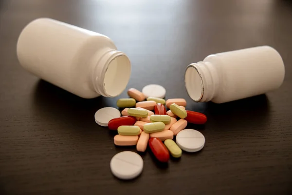 Siyah arka planda kavanozlar dolusu ilaç. Aspirin tabletleri. Yeşil, pembe ve kırmızı tabletler. Yüksek kalite fotoğraf