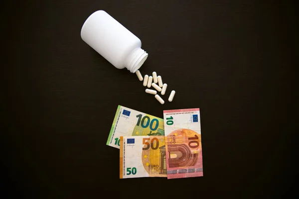 Банка Таблетками Лекарственные Капсулы Черном Столе Евро Бумажными Банкнотами Разброс — стоковое фото