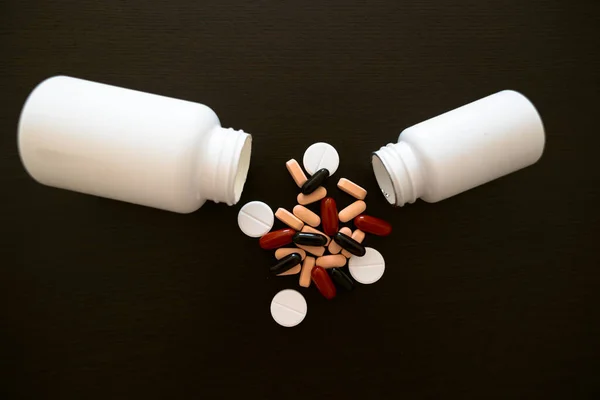 Two White Jars Scattered Red Pink Black Medicines Dark Table — Stock Photo, Image