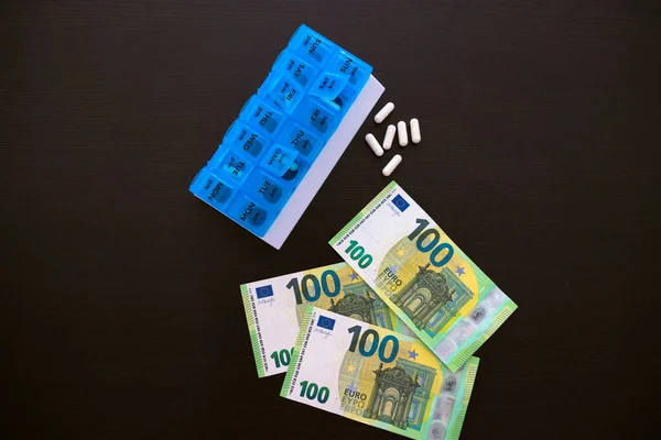 Siyah bir masanın üzerindeki tabletin yanında beyaz tabletler var. 100 Euro. Yukarıdan bak. Yüksek kalite fotoğraf