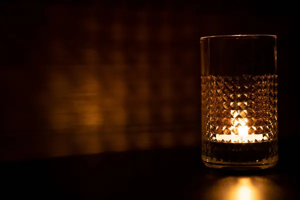 술잔에 굴절된다 탁자와 촛불을 반사하는 — 스톡 사진