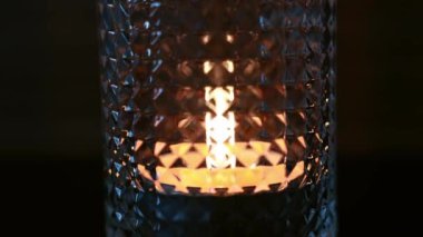 Mum alevi bardakta titreşiyor. İçi mum dolu bir bardağın yakın çekimi. Yüksek kaliteli FullHD görüntüler