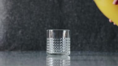 Portakal suyu çerçevede olmayan bir şişeden bardağa dökülür. Bardak masanın üstünde. Yüksek kaliteli FullHD görüntüler