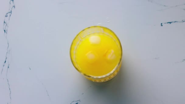 Apelsinjuice Med Isbitar Snurrar Runt Ett Glas Bordet Högkvalitativ Fullhd — Stockvideo