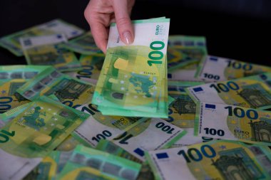 Banknotlar yığını Euro 'yu kadınların eline tutuşturdu. Banknotlar üzerinden Euro nakit para. Yüksek kalite fotoğraf