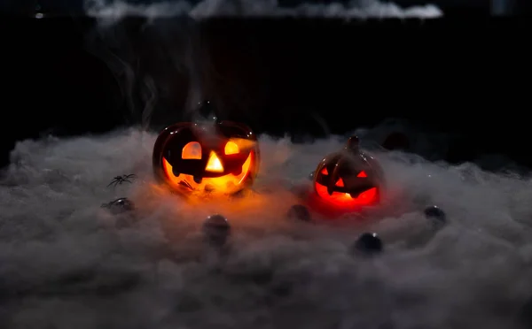 Halloween pumpkin face lantern at night with misty smoke. Halloween pumpkin face lantern at night with misty smoke. A terrible pumpkin with burning eyes, a cloud of smoke enveloped it.