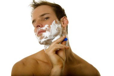 Genç bir erkek tıraş olurken sakalını tıraş ediyor.