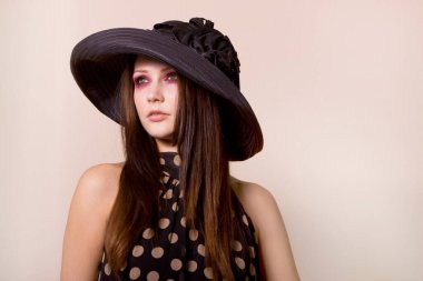 Puantiyeli elbiseli güzel, şık bir genç kadın.