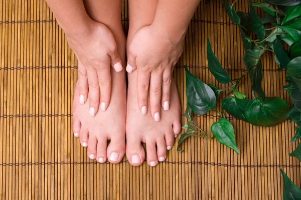 Bambu hasırında kadınların pedikürlü ayakları