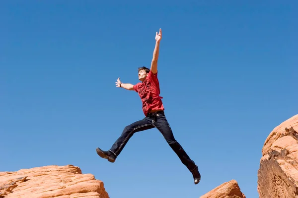 Beau Jeune Homme Sautant Sur Des Rochers Rouges — Photo