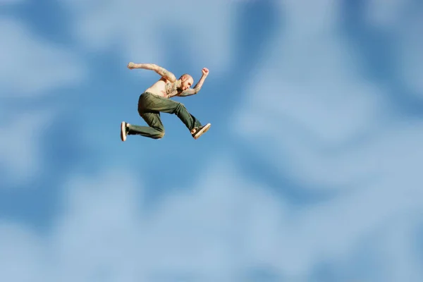 纹身的男人在空中跳得很高 — 图库照片