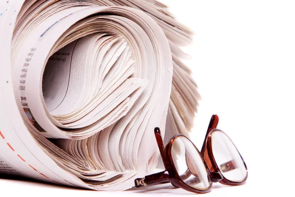 Beyaz arka planda rulo gazete ve okuma gözlüğü
