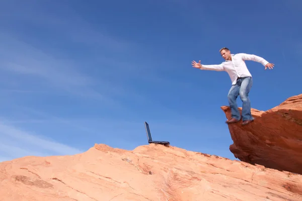 Молодой Человек Улице Ноутбуком Прыгающий Красных Скалах — стоковое фото