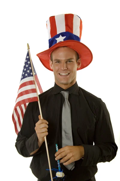 7月4日の帽子をかぶってアメリカ国旗を掲揚する若者 — ストック写真