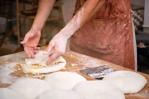 Detail of a bakers hands introducing ingredients into the bread dough. . High quality photo