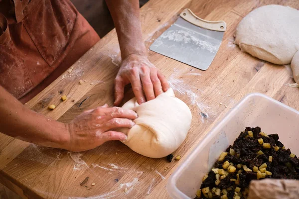 Detail of a bakers hands introducing ingredients into the bread dough. . High quality photo