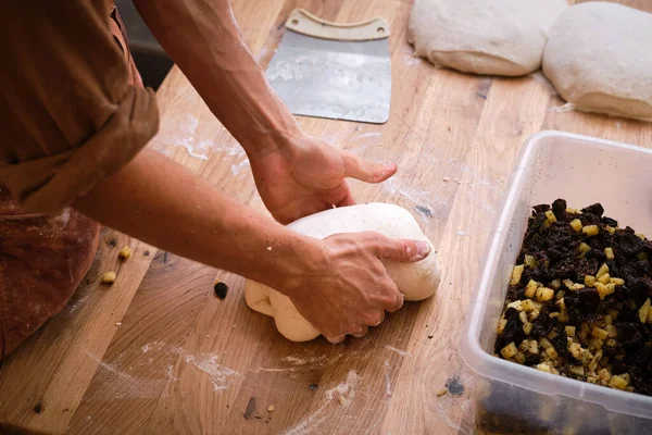 Detail of a bakers hands introducing ingredients into the bread dough. . High quality photo