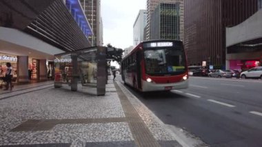 Sao Paulo, Brezilya, 30 Kasım 2021 Paulista Bulvarı 'ndaki otobüs durağında yağmurlu bir günde yolcu ve araç hareketi.