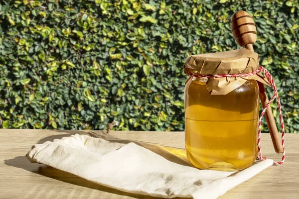 蜂蜜のディップと木の棒で蜂蜜 ブラジルの緑の植物の背景を持つ木製のテーブルの上に有機花蜂蜜 — ストック写真
