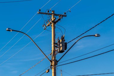 Elektrik direğine bağlı birçok kablo, elektrik direğindeki kablolar ve kablolar karmaşası, mavi gökyüzü arka planı, Brezilya 'daki teknolojik kombinasyon konsepti