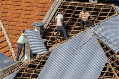 Marilia, Sao Paulo, Brezilya, 29 Temmuz 2022. Marilia 'nın merkezindeki ticari bir noktanın çatısını yenilemek için bir eve metal çarşaf döşeyen bir işçinin üst görüntüsü.