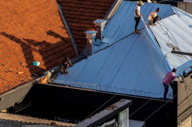 Marilia, Sao Paulo, Brezilya, 29 Temmuz 2022. Marilia 'nın merkezindeki ticari bir noktanın çatısını yenilemek için bir eve metal çarşaf döşeyen bir işçinin üst görüntüsü.