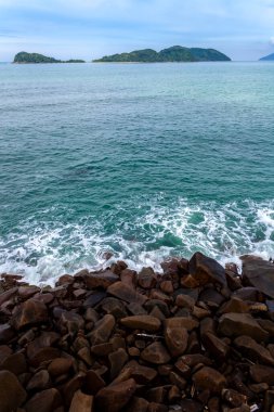 ocean waves beat against the rocks. We can see the foam on the sea. The rushed ocean, and ravishing warm water in Brazil