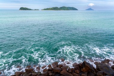 ocean waves beat against the rocks. We can see the foam on the sea. The rushed ocean, and ravishing warm water in Brazil