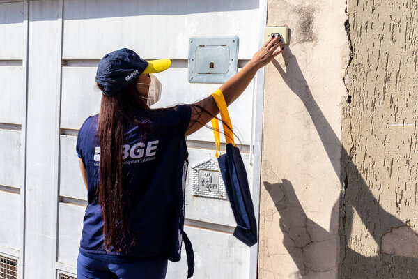 Марилия, Бразилия, 1 августа 2022 года. Переписчик у двери дома, чтобы собрать данные переписи 2022 года в городе Марилия. Переписчики Бразильского института статистики и статистики, БИГС