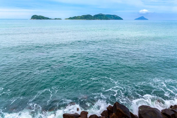 ocean waves beat against the rocks. We can see the foam on the sea. The rushed ocean, and ravishing warm water in Brazil