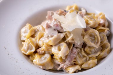 Parmesanlı taze, sıcak tortellini carbonara.