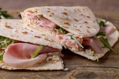 details of tasty italian piadina with ham and arugula clipart