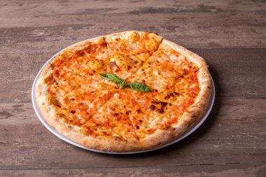Tahta masadaki lezzetli margherita pizzasının ayrıntıları.