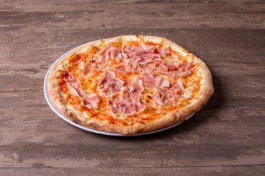 Ahşap arka planda mozzarella ve jambonlu pizzanın detayları