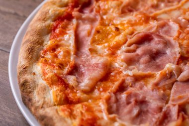 Ahşap arka planda mozzarella ve jambonlu pizzanın detayları