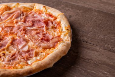 Ahşap arka planda mozzarella ve jambonlu pizzanın detayları