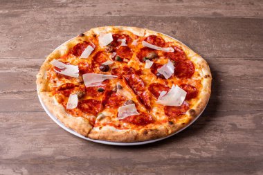 Zeytinli ve parmesanlı taze salamlı pizzanın detayları.