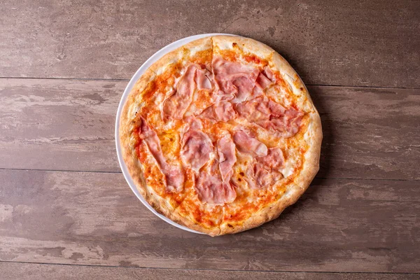 Ahşap arka planda mozzarella ve jambonlu pizzanın detayları