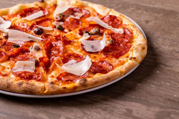 焼きたてのサラミ ピザにオリーブとパルメザン フレーク ロイヤリティフリーのストック画像