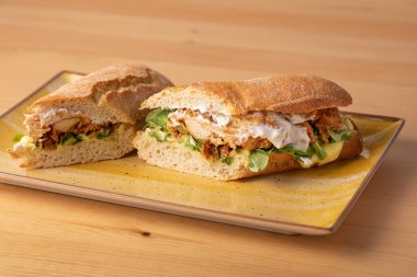 Tahta masadaki kızarmış tavuklu sandviçin detayları. 