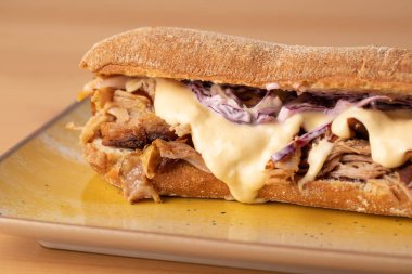 Lezzetli erimiş peynirli sandviç, ahşap masada.