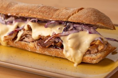 Lezzetli erimiş peynirli sandviç, ahşap masada.