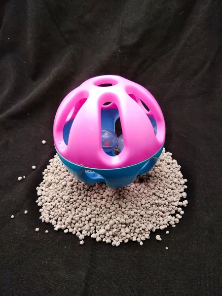 黑色背景下的粉色和蓝色塑料猫玩具球 — 图库照片